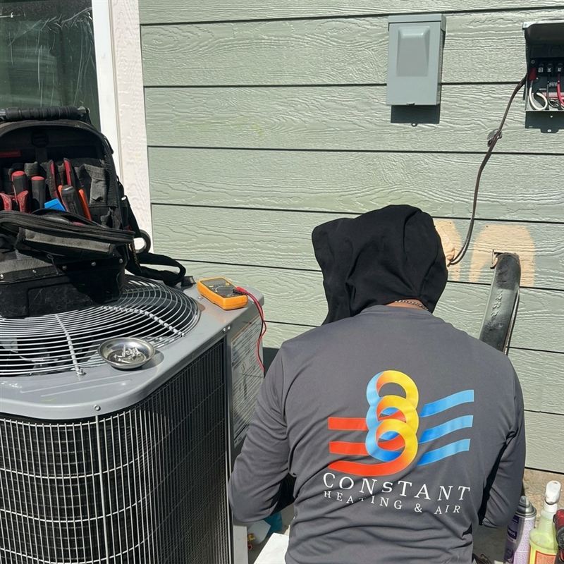 Technician performing maintenance on an AC unit